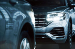 Powerful headlights. Particle view of modern luxury cars parked indoors at daytime.